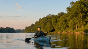 A man in his 40s kayaks on a still river