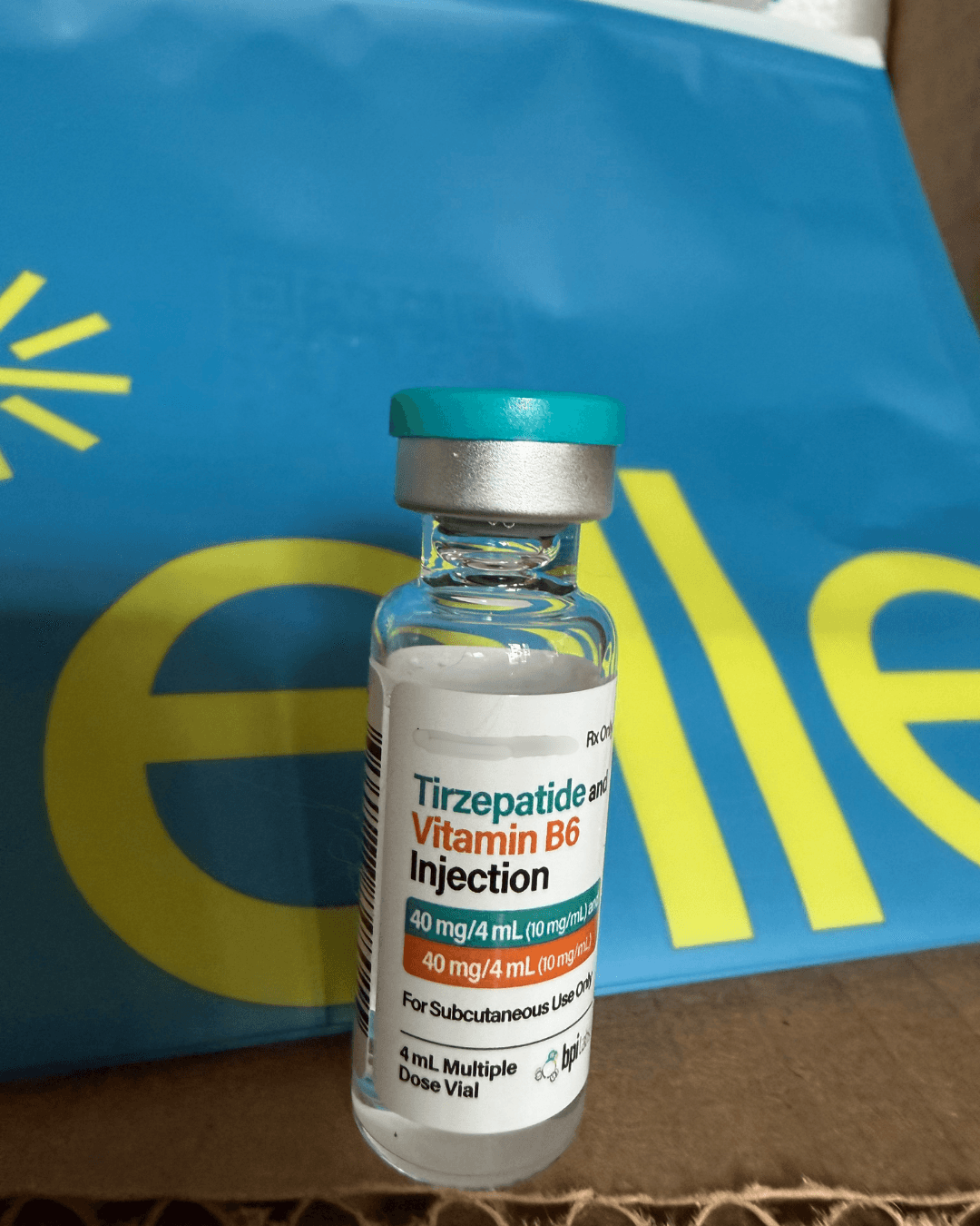 BPI Labs Tirzepatide and Vitamin B6 Injection 40 mg/4 mL multiple dose vial with teal cap standing on a Belle pouch