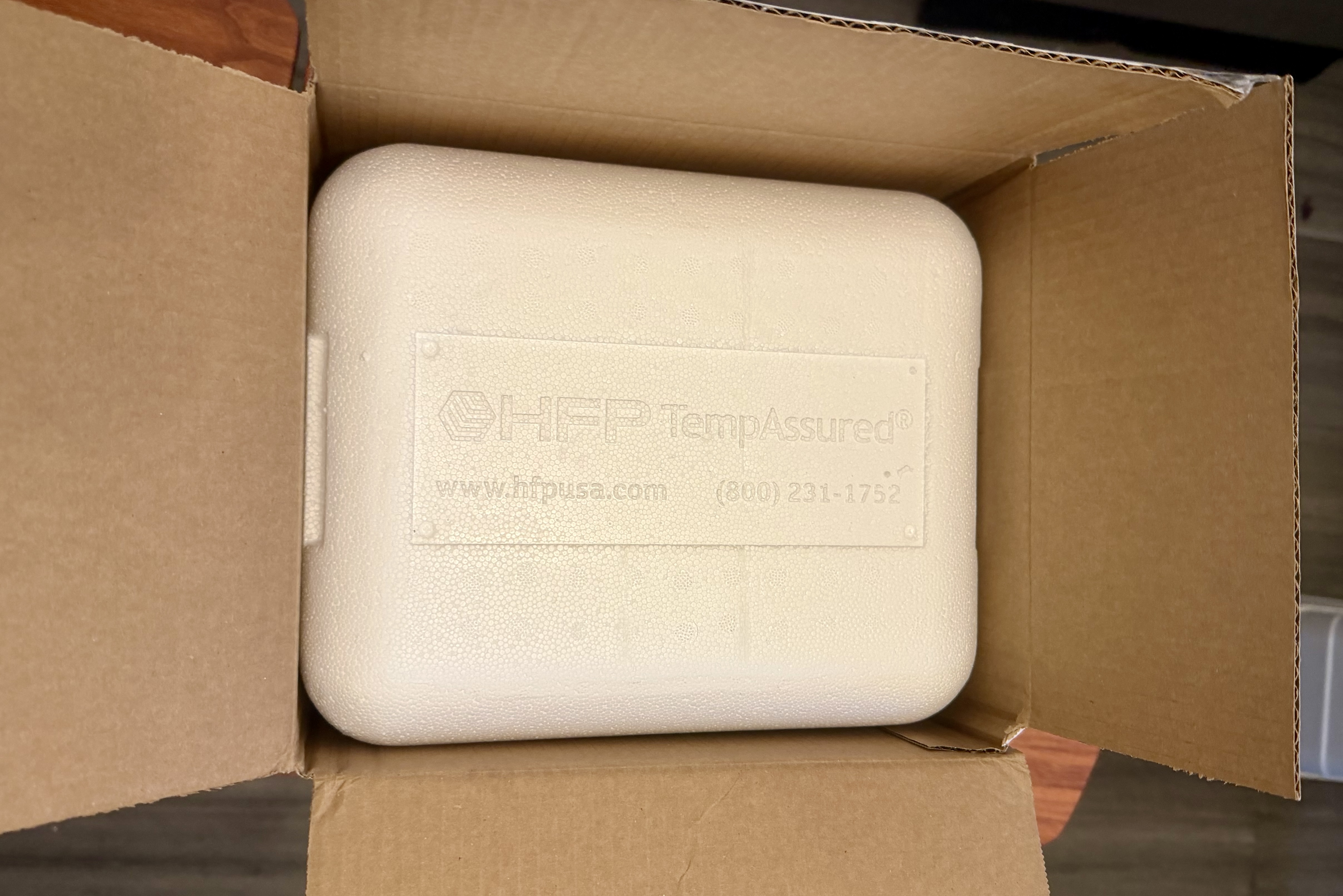 Plain cardboard Goby Meds shipping box opened to reveal an HFP TempAssured styrofoam cooler with no branding on the outside