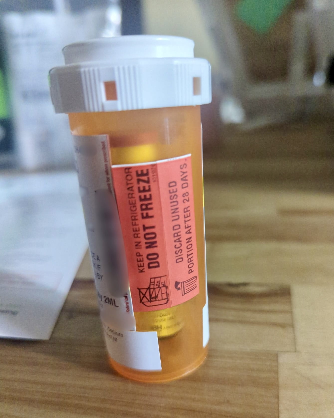 Orange sticker on the Ivim Health pharmacy bottle reading Keep in refrigerator, do not freeze, discard unused portion after 28 days