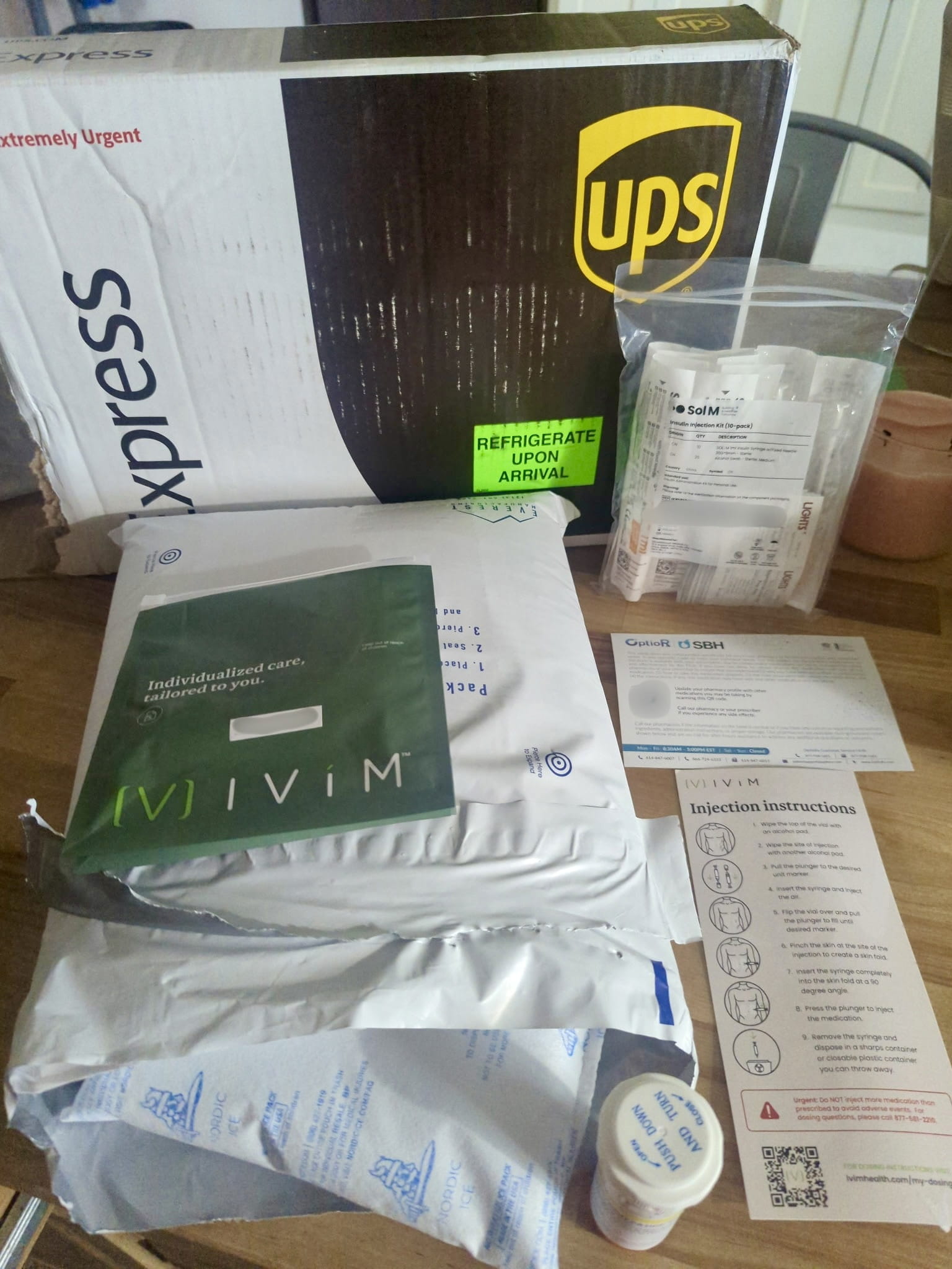 Full Ivim Health box contents: green zip pouch, opened insulated mailer with gel packs, syringe bag, pharmacy card, injection card and bottle