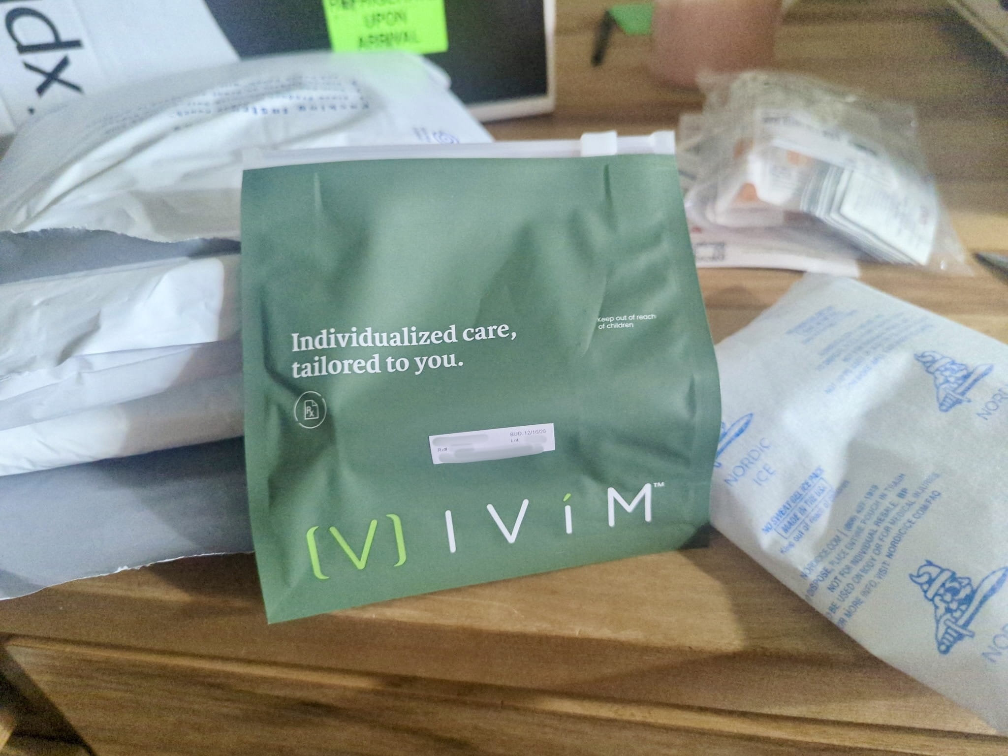 Green Ivim Health zip pouch printed Individualized care, tailored to you, next to a Nordic Ice pack and the opened shipping pouch