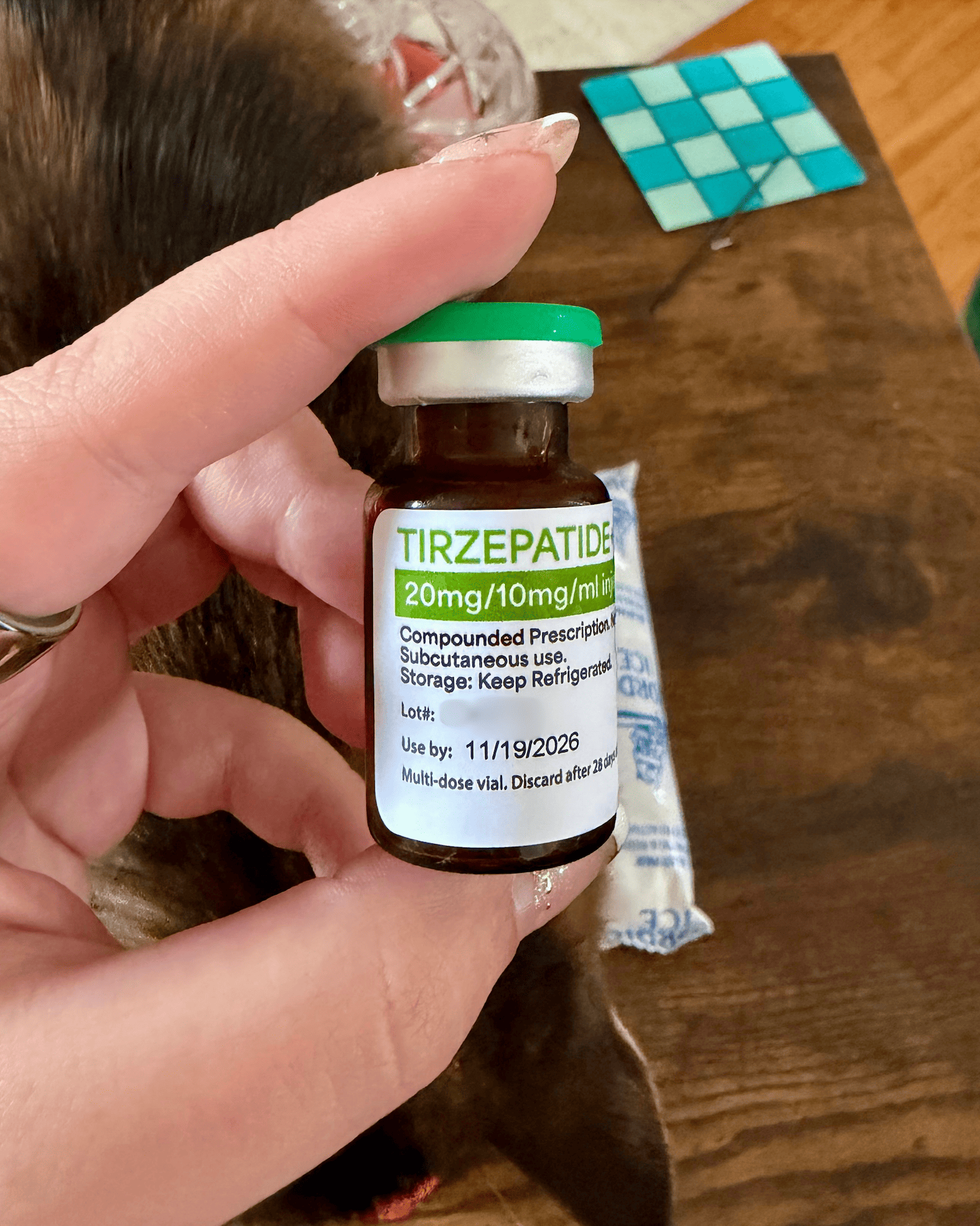 Amber vial with green flip cap labeled tirzepatide 20mg/10mg/ml compounded prescription, keep refrigerated, discard after 28 days