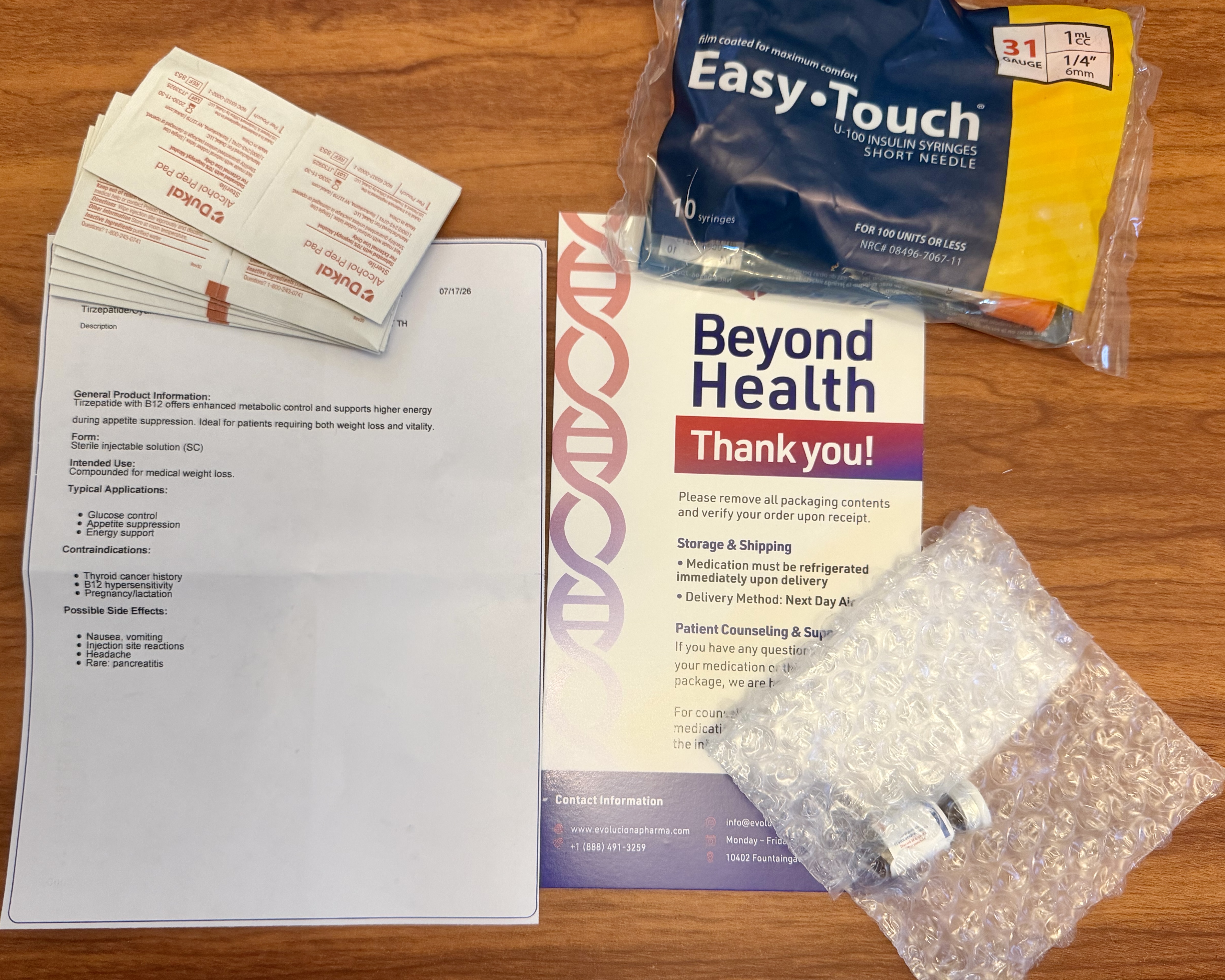 Goby Meds order contents laid out: tirzepatide with cyanocobalamin product sheet, Dukal alcohol pads, Easy Touch 31-gauge syringes, and the bubble-wrapped vial