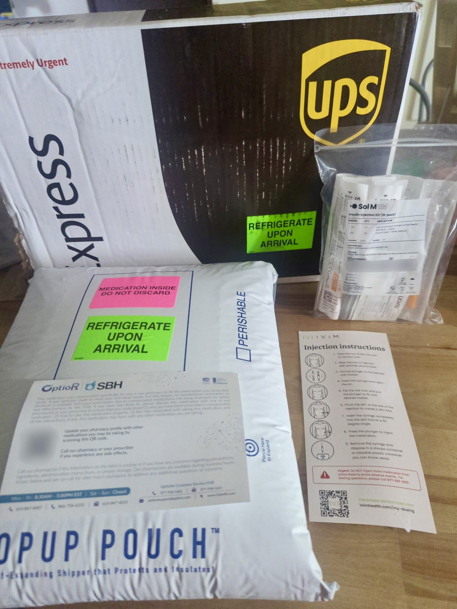 Ivim Health shipment unboxed: a UPS Express box, an insulated Popup Pouch with refrigerate stickers, syringes, a pharmacy card and an injection card