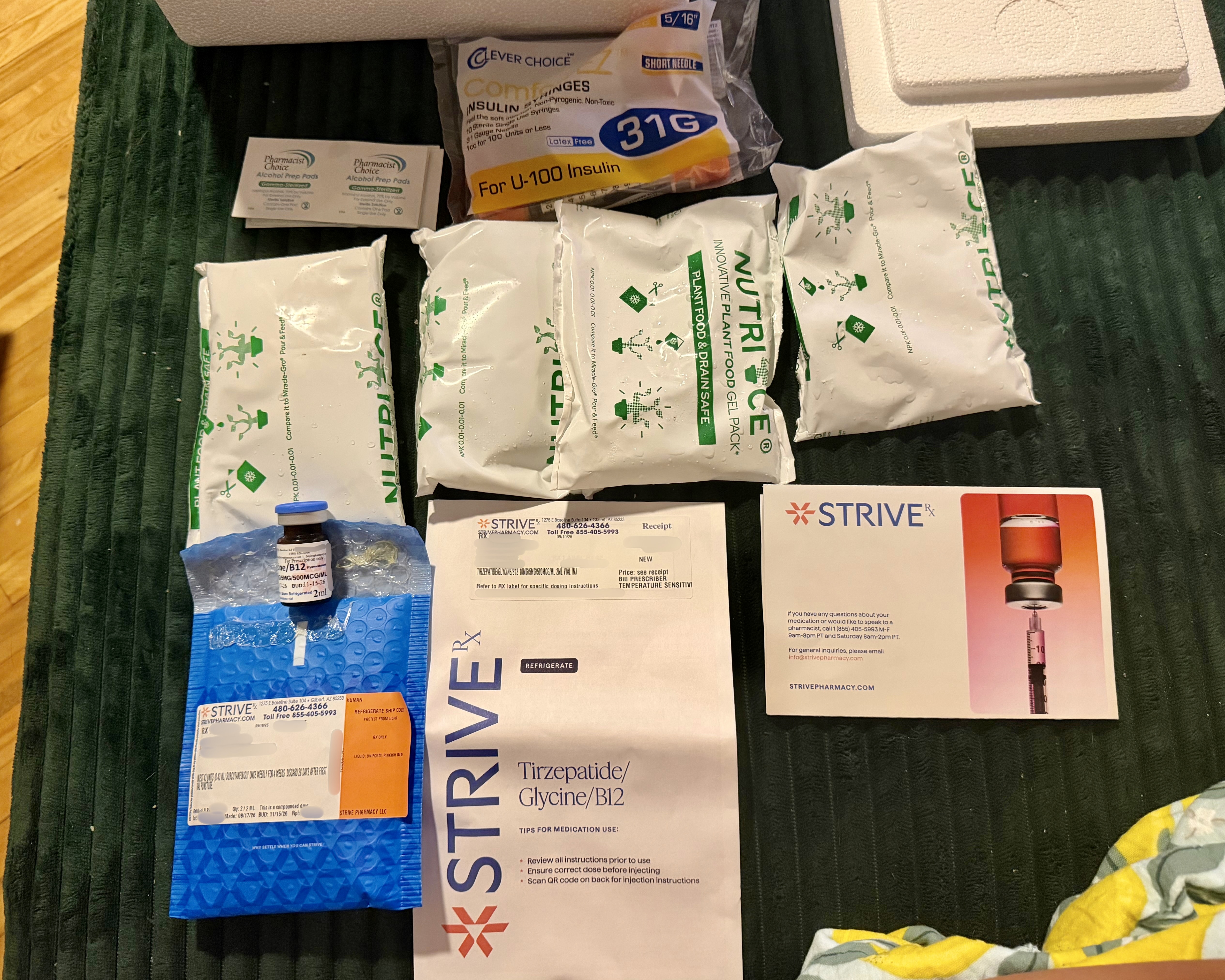 Everything from the MEDVi order laid out: four Nutri-Ice packs, the vial in a blue Strive mailer, syringes, alcohol pads, receipt, and pharmacist card